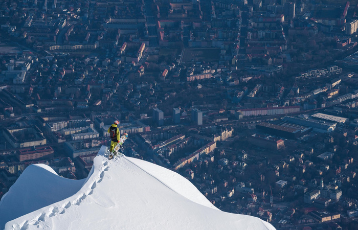 Snowboarder auf Gipfel vor Innsbruck-Panorama