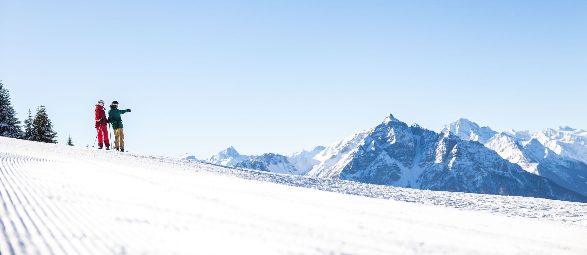 Zwei Skifahrer auf einer Piste.