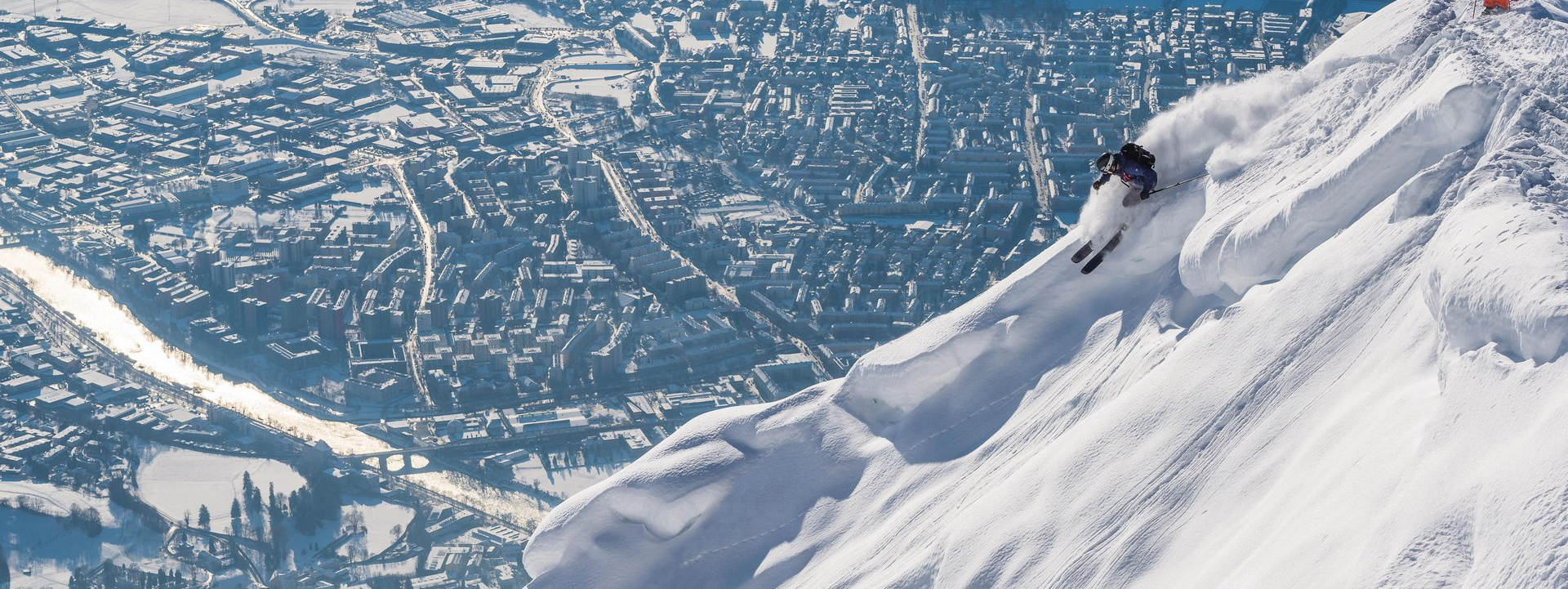 Freerider auf der Piste mit Blick auf Innsbruck. Das Skigebiet Nordkette ist in deinem SKI plus CITY Pass Stubai Innsbruck inkludiert.