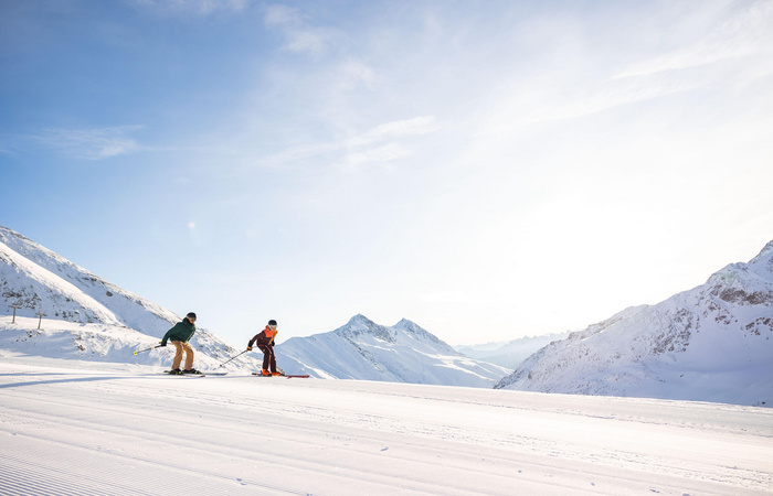Zwei Skifahrer auf der Piste. Das Skigebiet Kühtai ist im SKI plus CITY Pass Stubai Innsbruck inkludiert.