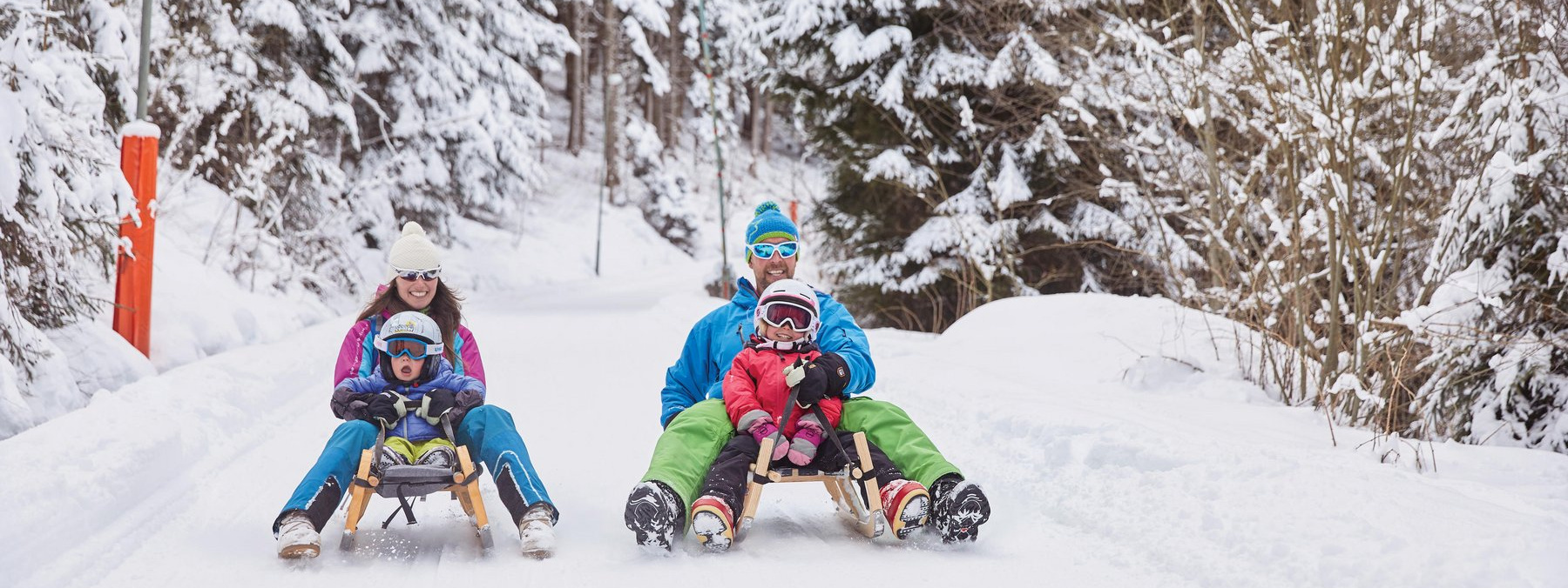 Eine Familie beim Rodeln. Das Skigebiet Rangger Köpfl ist im SKI plus CITY Pass Stubai Innsbruck inkludiert.