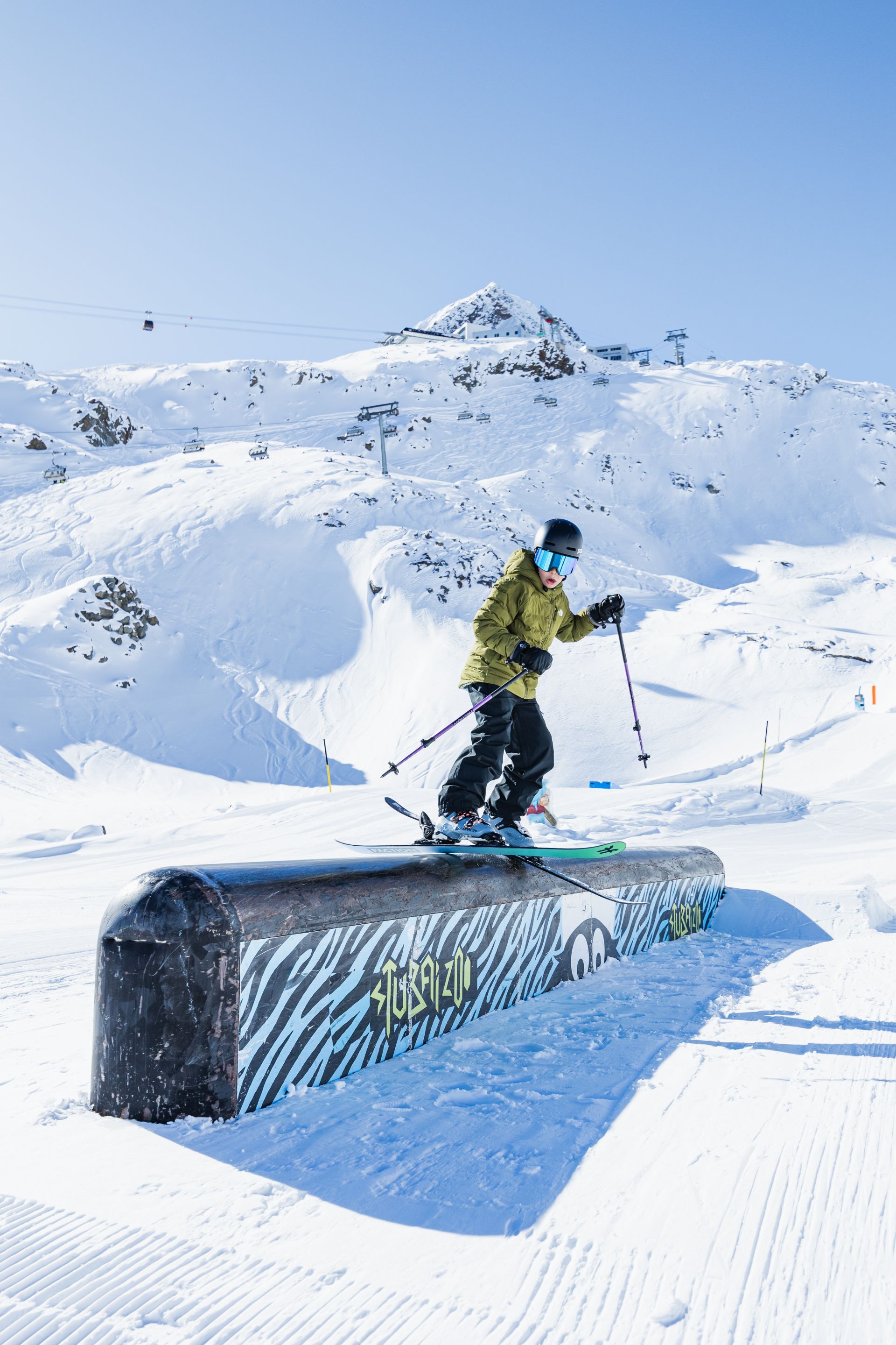 Ein junger Skifahrer fährt über ein Hindernis.