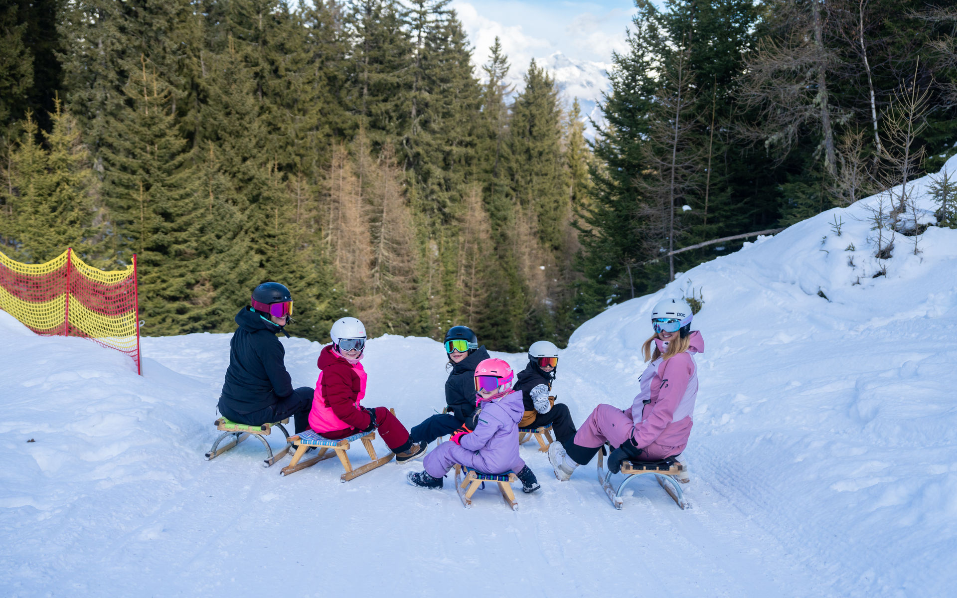 Eine Familie sitzt auf Rodeln und posiert für ein Foto.