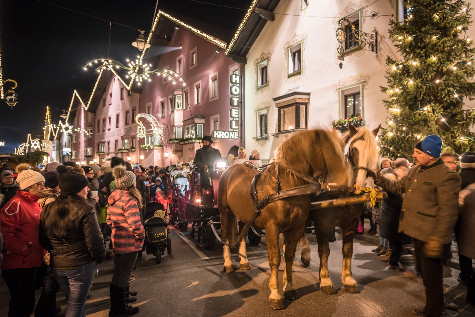 Weihnachtliche Straße mit Pferdekutsche und Zuschauern